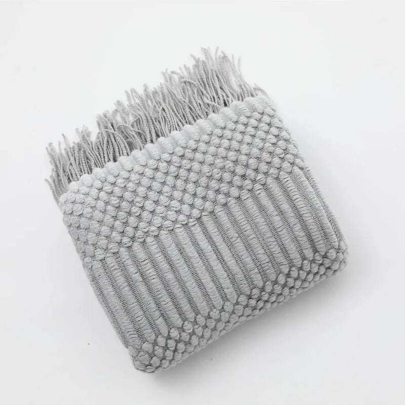 Knitted soft throw blanket with tassels in light grey, featuring intricate woven texture and available in 10 colors for cozy home decor.