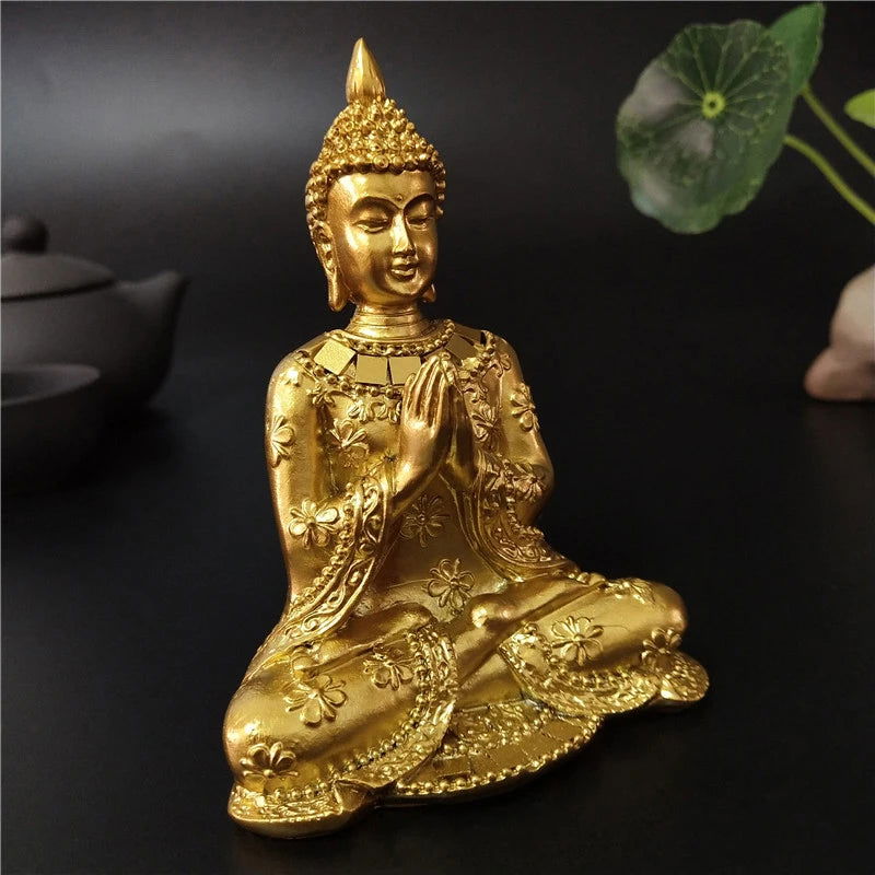 Gold seated Thai Buddha statue with Anjali Mudra, symbolizing serenity and spiritual enlightenment.