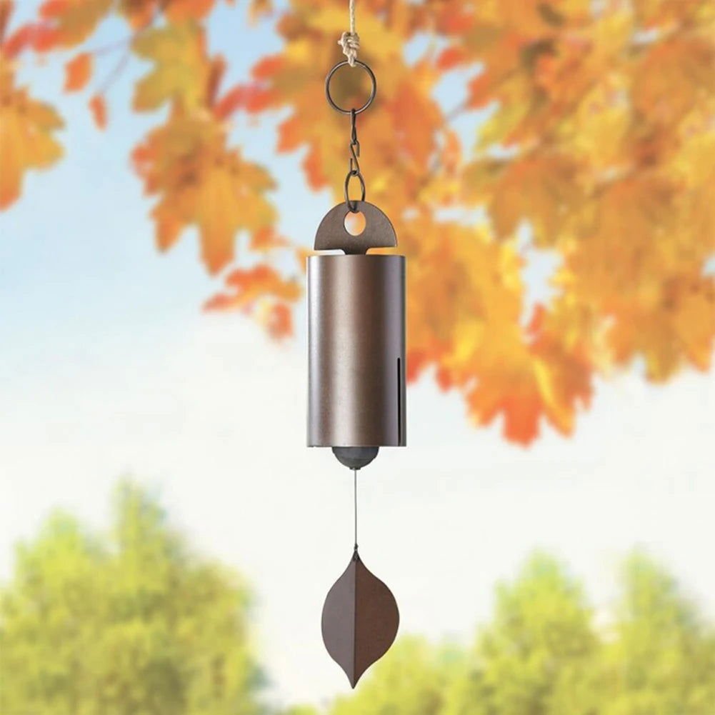 Metal wind chimes with retro design, featuring a leaf-shaped pendant, hanging outdoors against autumn foliage.